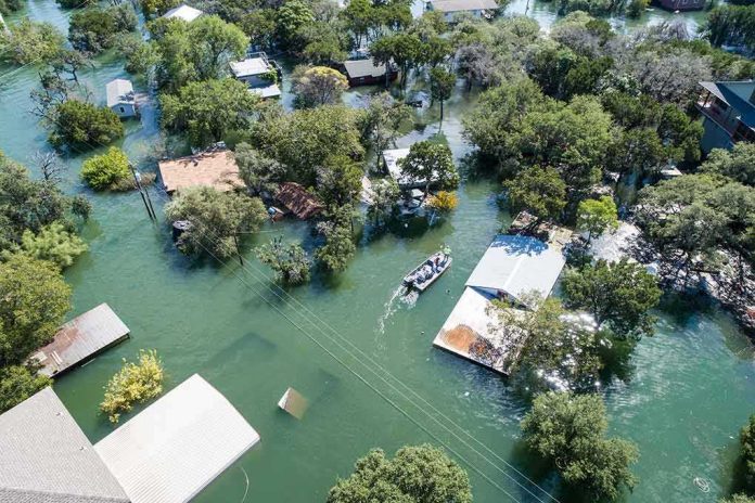 shutterstock_1213793479 Aerial view of flooded neighborhood with rescue boat navigating streets
