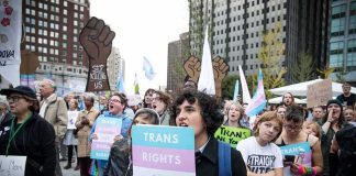 GOP Gay Group Ditches Trans — Why Now? Protesters holding signs at a transgender rights rally