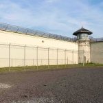 Prison yard with chain-link fence and guard tower