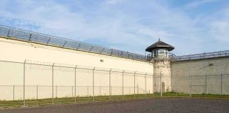 Prison yard with chain-link fence and guard tower