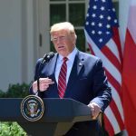 man at presidential podium speaking outdoors