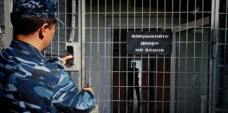 Trump-Putin Deal Frees Marine Prisoner Security officer locking a metal gate with keypad