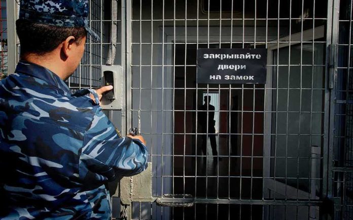 Security officer locking a metal gate with keypad