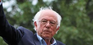Bernie Sanders Torches Democratic Donor Class older man in suit and glasses outdoors