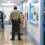 New Testimony Triggers High-Level Arrest Corrections officers escort an inmate in a jail hallway