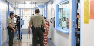 New Testimony Triggers High-Level Arrest Corrections officers escort an inmate in a jail hallway