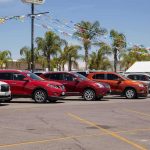 Trade War Reloaded: Cars In The Crosshairs row of SUVs at a car dealership lot