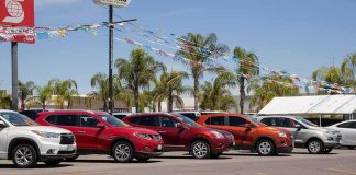 Trade War Reloaded: Cars In The Crosshairs row of SUVs at a car dealership lot