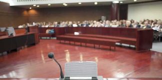 Fauci Considered Criminal Suspect For His Fifth Amendment Firestorm Conference microphone on a podium in a courtroom
