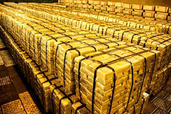 Stacks of gold bars strapped together in a vault