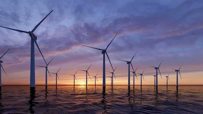 shutterstock_2134923625 Offshore wind turbines at sunset over calm sea