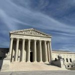 Supreme Court building with grand columns under a blue sky