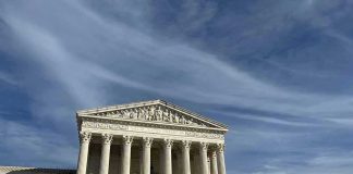Supreme Court building with grand columns under a blue sky