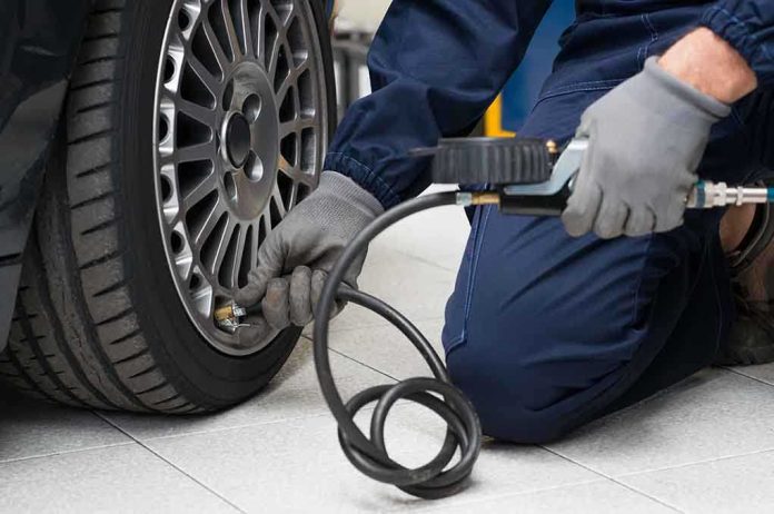 Mechanic inflating a car tire in a workshop
