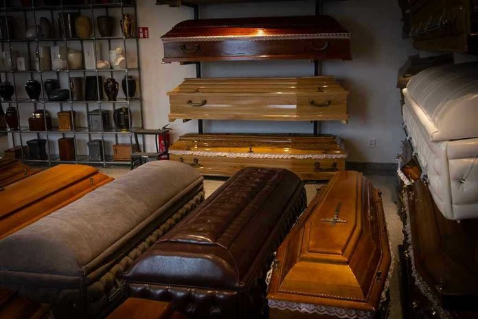2183836499 Wooden coffins and urns displayed in a showroom.