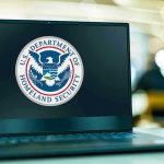 Federal Databases Eye Ballots — Alarms Ring Laptop displaying U.S. Department of Homeland Security logo.