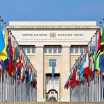 UN Showdown: Trump Defies Global Control United Nations building with numerous national flags outside.