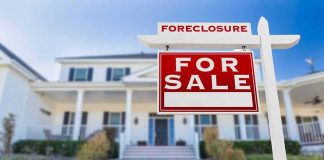 Shocking Hike: Fed Jacks Rates Again For sale sign in front of suburban house