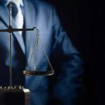 Postpartum Psychosis Bombshell Splits Jury Scales of justice held by a person in a suit