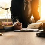 Lawyer’s Hail Mary: Pardon That Can’t Happen Lawyer writing at desk with scales and gavel