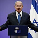 Regime-Change Playbook Quietly Emerges man in suit speaking at a podium with Israeli flag