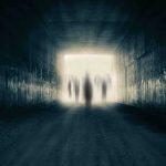 Silhouetted figures at the end of a dark tunnel