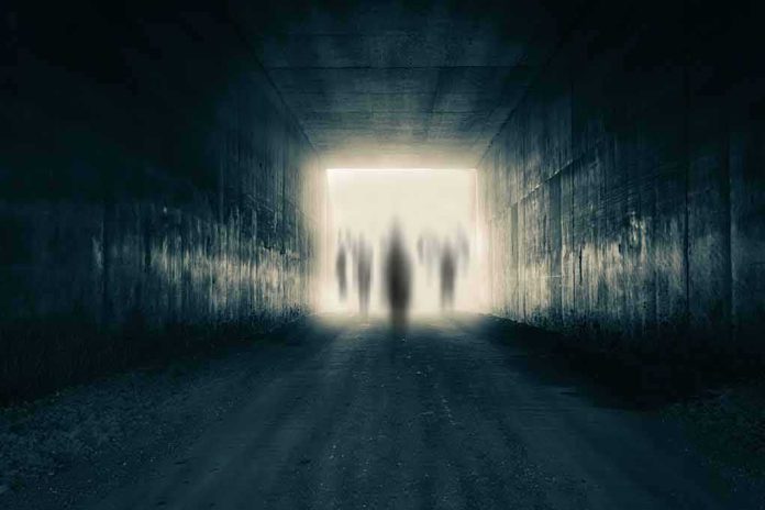 shutterstock_1266330655 Silhouetted figures at the end of a dark tunnel