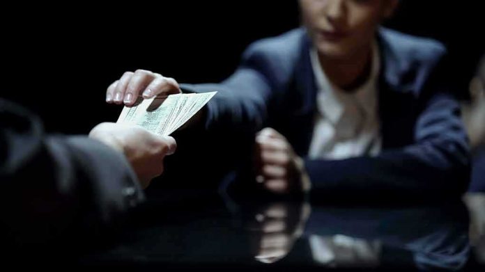 shutterstock_1295252023 Hands exchanging cash across a table