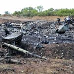 Airplane crash debris scattered across a burned field
