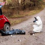 Lab Employee Found Dead—Gun Nearby forensic investigator photographing evidence near red car on dirt road