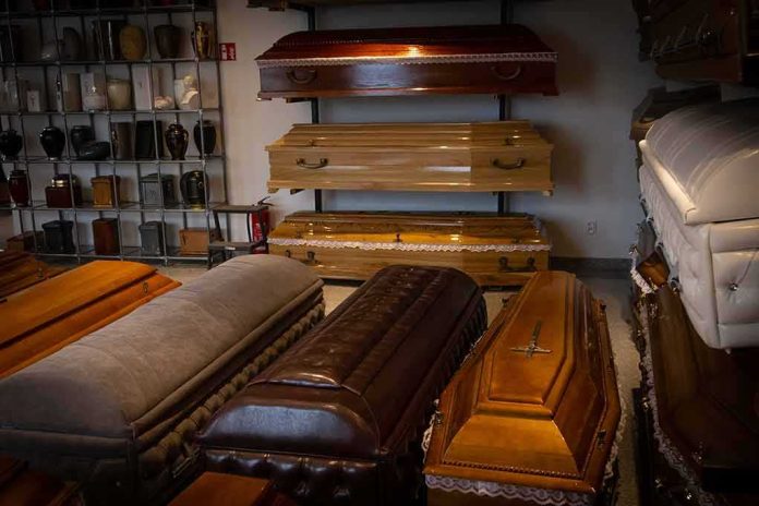 Row of coffins displayed in a funeral home showroom