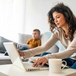 Shock Shift: Stay-Home Parents Cash In Woman working on laptop while child uses tablet on sofa