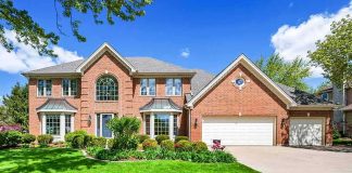 Brick suburban house with two-story facade and three-car garage