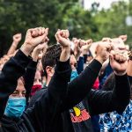 Huge Fund Stokes Rage In Baby Death Case Crowd of protesters with raised fists wearing masks