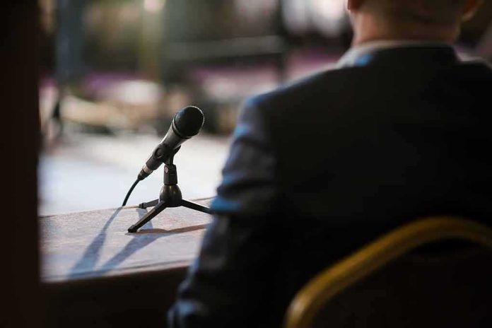 Microphone on a table near a seated person in a suit