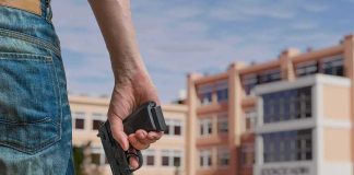 Person holding a handgun near a school building