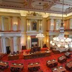 Senate Meltdown: GOP Split Halts Voting Crackdown Legislative chamber with red carpet and chandeliers