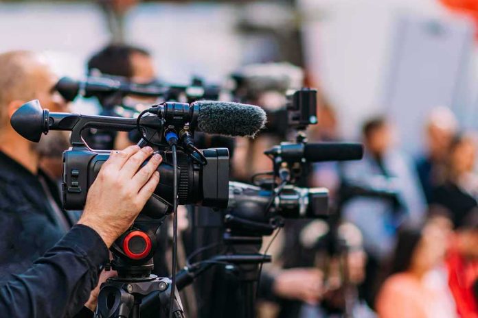 shutterstock_2233193507 Video cameras on tripods at a media event