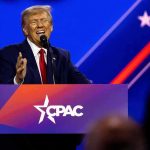 Donald Trump speaking at a podium on a brightly lit stage