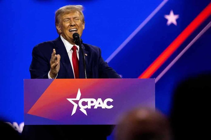 shutterstock_2272007697 Donald Trump speaking at a podium on a brightly lit stage