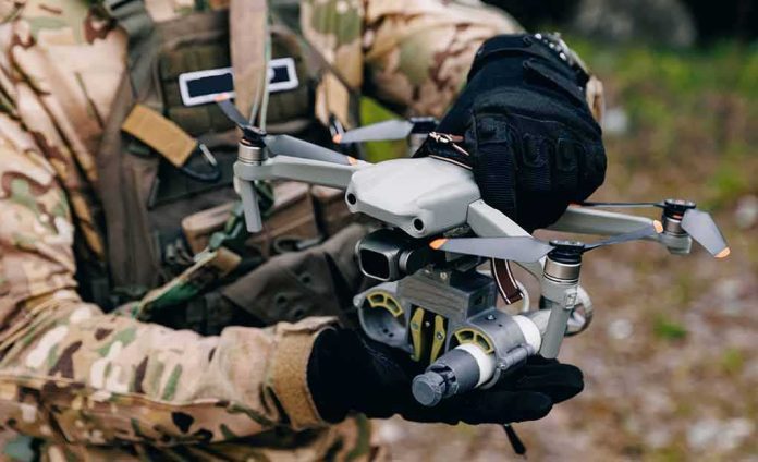 shutterstock_2477270379 Soldier holding a quadcopter drone with attached device