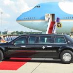Red Carpet Gamble With Beijing Presidential limousine beside a large blue-and-white jet on a runway