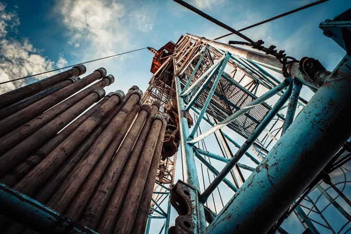 Oil drilling rig structure with stacked pipes viewed from below
