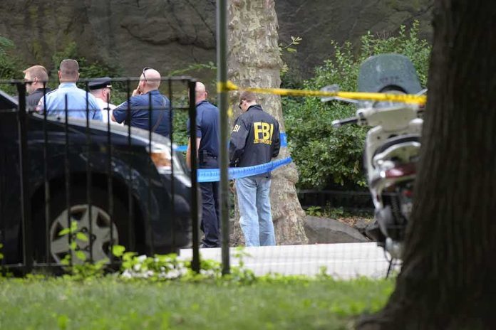 shutterstock_451587268 law enforcement officers gather at taped-off outdoor scene