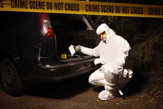 forensic investigator at car trunk behind crime scene tape