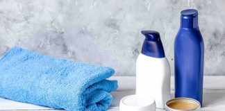 bathroom toiletries with blue towel and wooden comb on white surface