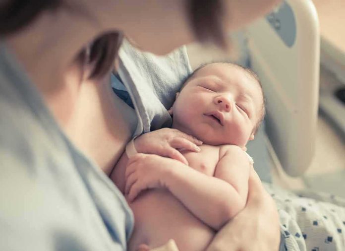 shutterstock_663728050-1 newborn baby sleeping in a parent's arms
