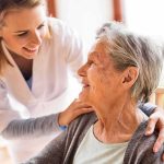 Hospitals Overflow As Heatwave Hits Caregiver smiling at an elderly woman