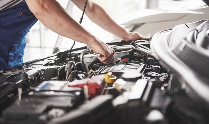 shutterstock_759448675 Mechanic working on a car engine bay