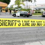 Mall Chaos Sparks Trust Meltdown yellow sheriff's line tape blocks a street near police cars